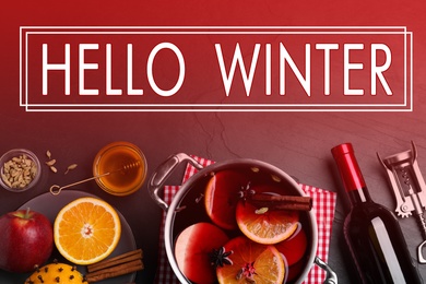 Image of Greeting card with text Hello Winter. Delicious mulled wine and ingredients on table, flat lay