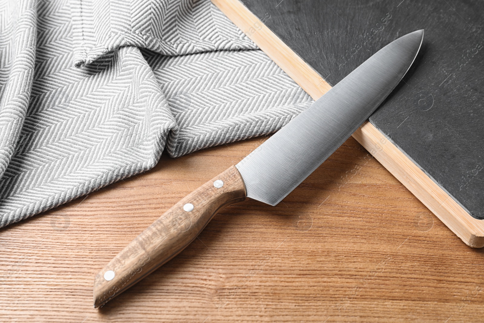 Photo of Composition with sharp chef's knife and board on wooden background