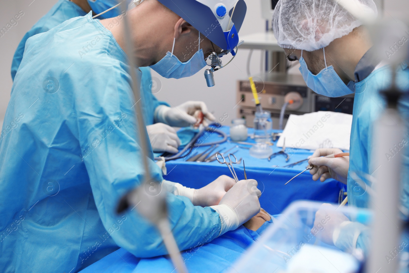 Photo of Professional doctors performing 
frontal sinus trephination in surgery room