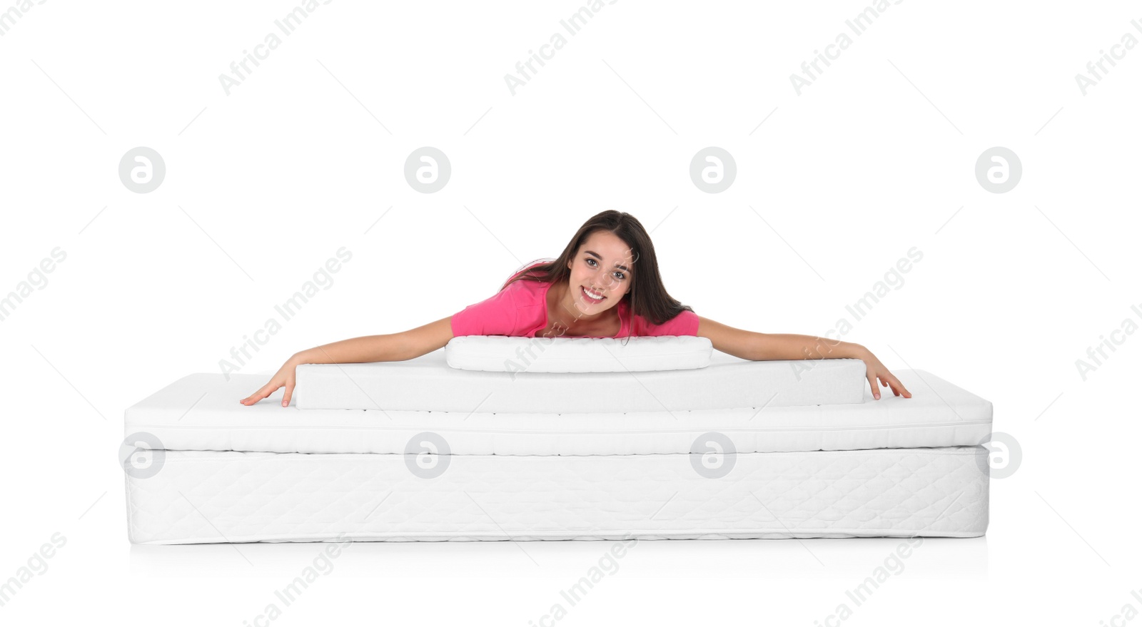 Photo of Young woman lying on mattress pile against white background