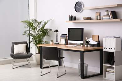 Photo of Modern computer on table in office interior. Stylish workplace