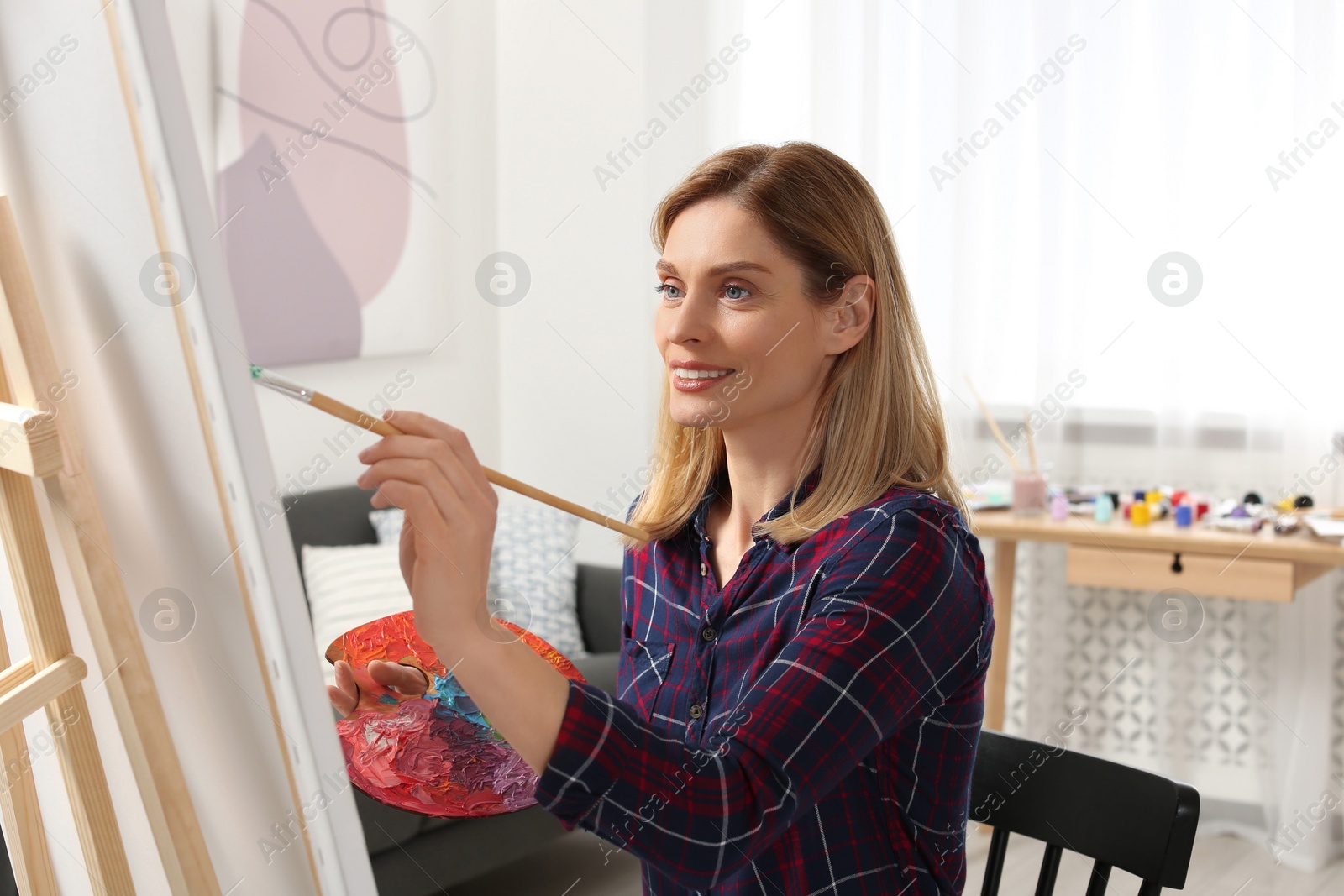 Photo of Beautiful woman painting in studio. Creative hobby