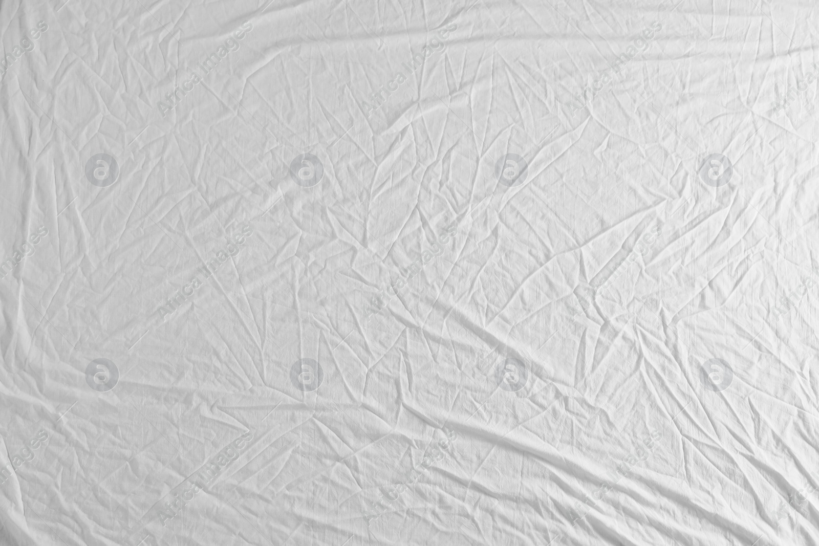 Photo of Crumpled white fabric as background, top view