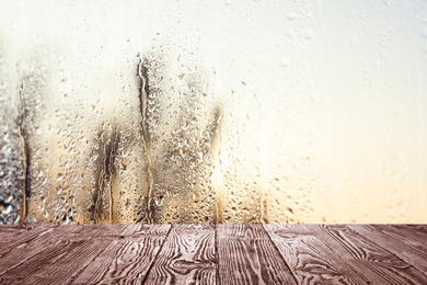 Wooden table near window on rainy day