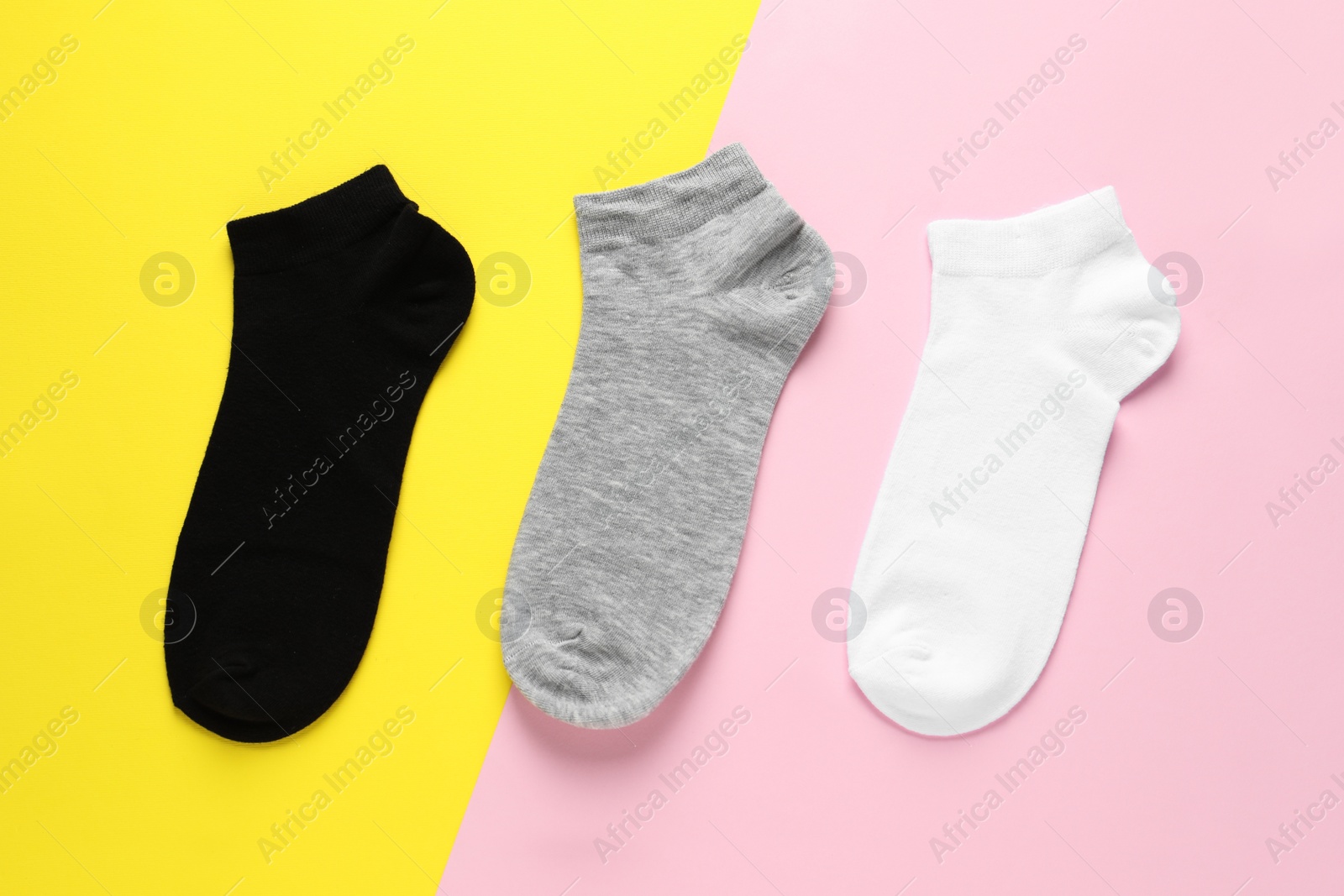 Photo of Different socks on colorful background, flat lay