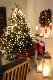 Blurred view of decorated room with Christmas tree and fireplace