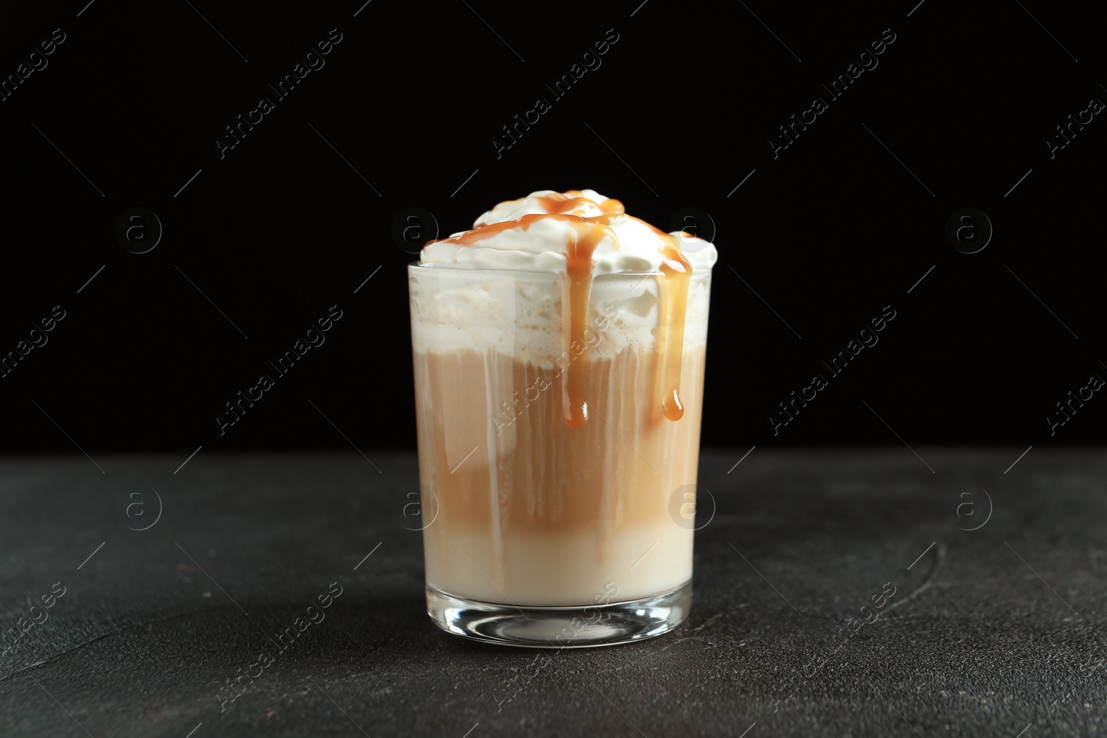 Photo of Glass with delicious caramel frappe on table