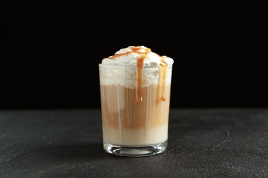 Photo of Glass with delicious caramel frappe on table