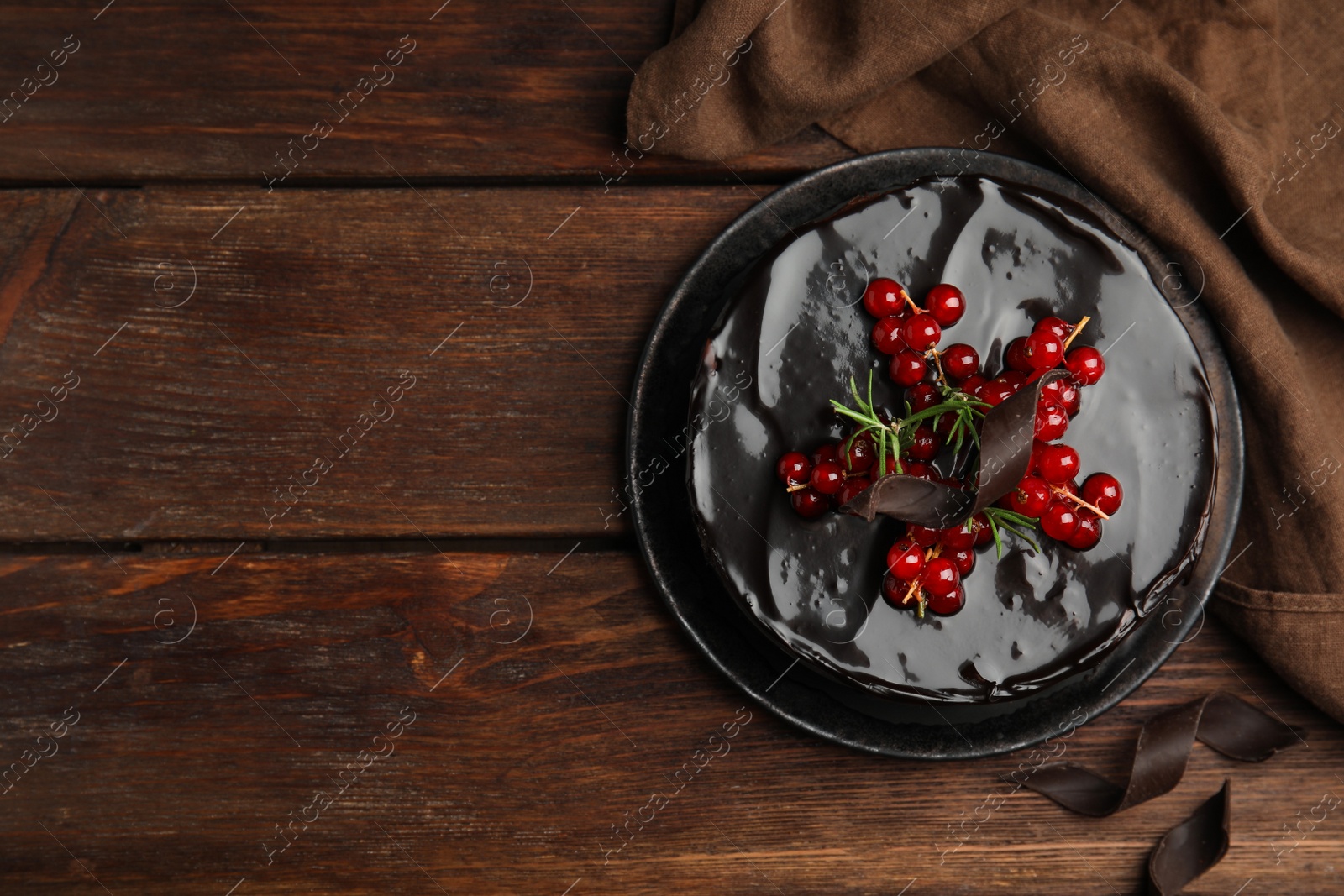 Photo of Tasty homemade chocolate cake with berries and rosemary on wooden table, flat lay. Space for text