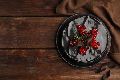 Photo of Tasty homemade chocolate cake with berries and rosemary on wooden table, flat lay. Space for text