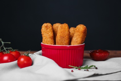 Photo of Bowl of cheese sticks on table against black background