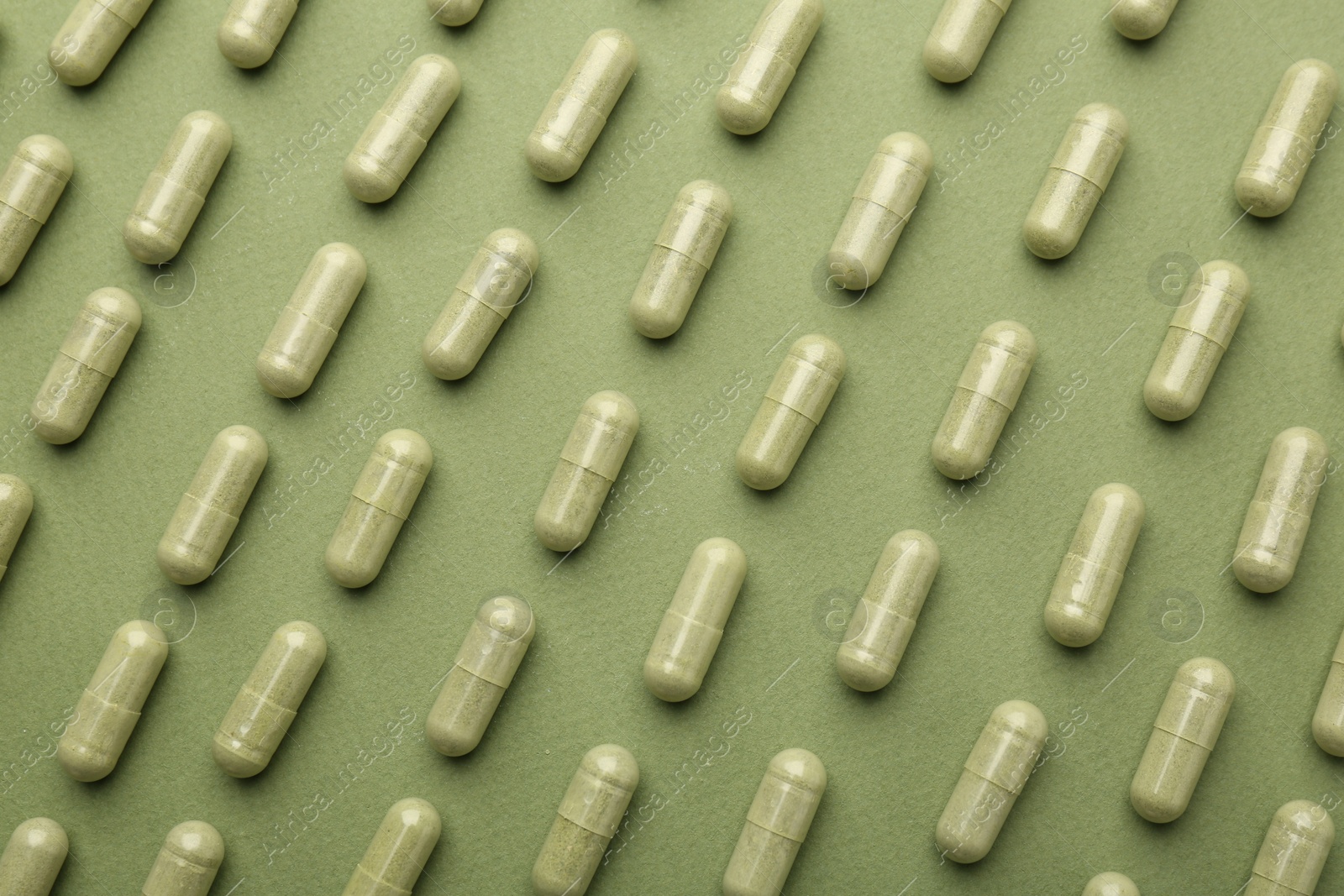 Photo of Vitamin capsules on olive background, flat lay