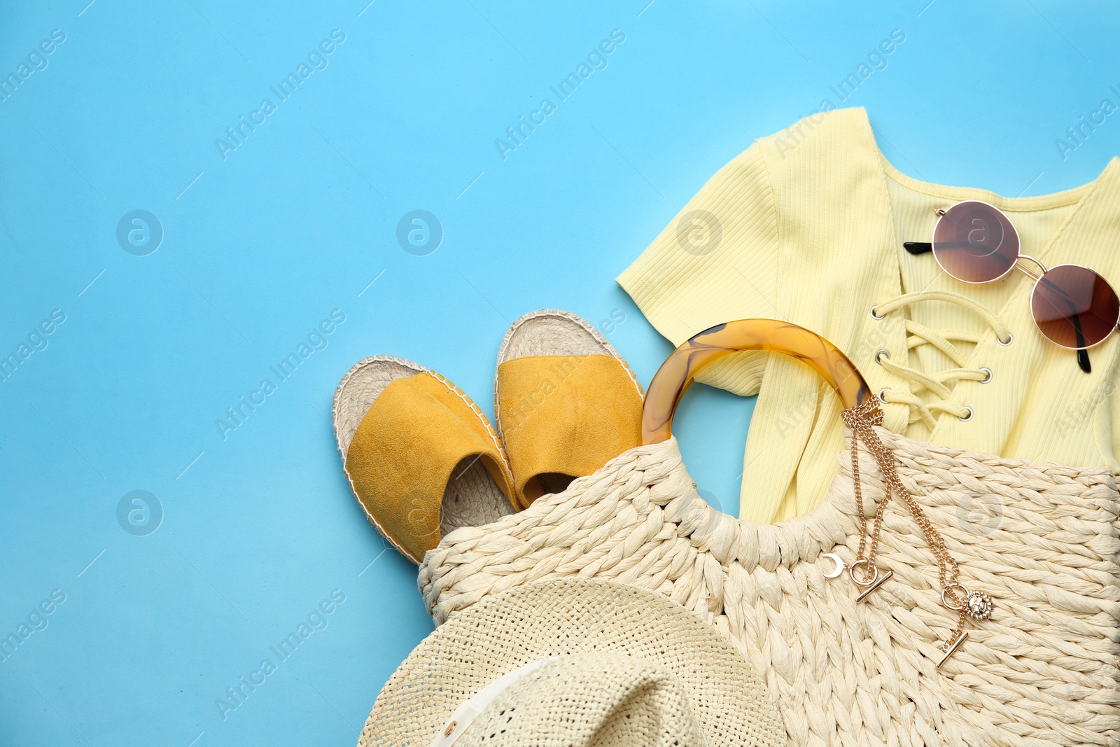 Photo of Flat lay composition with woman's straw bag on light blue background