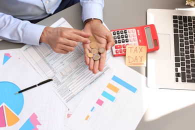 Tax accountant with money and documents at table