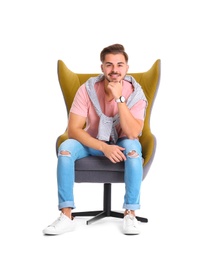 Photo of Handsome young man sitting in armchair on white background