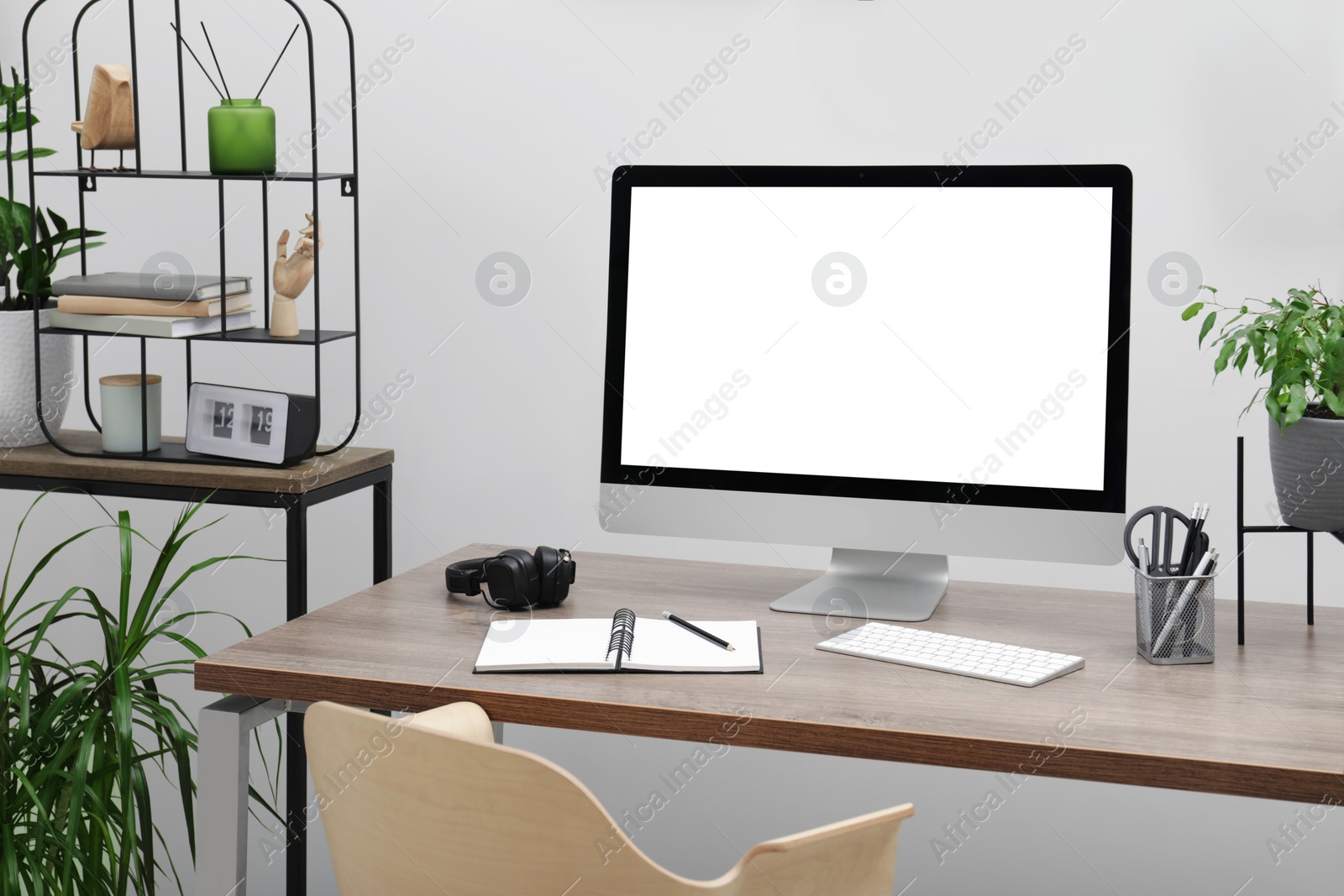 Image of Comfortable workplace at home. Modern computer with blank screen and stationery on wooden desk. Mockup for design