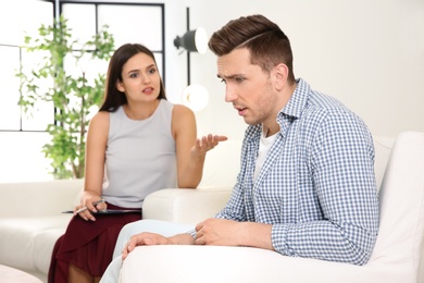 Photo of Depressed young man having appointment with psychologist in office