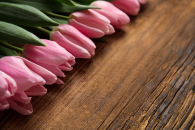 Beautiful pink spring tulips on wooden background, closeup. Space for text