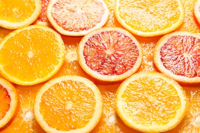 Photo of Slices of fresh citrus fruits as background, closeup