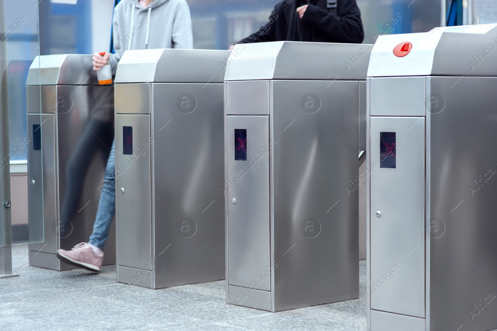 Photo of People passing turnstiles, closeup view. Fare collection system