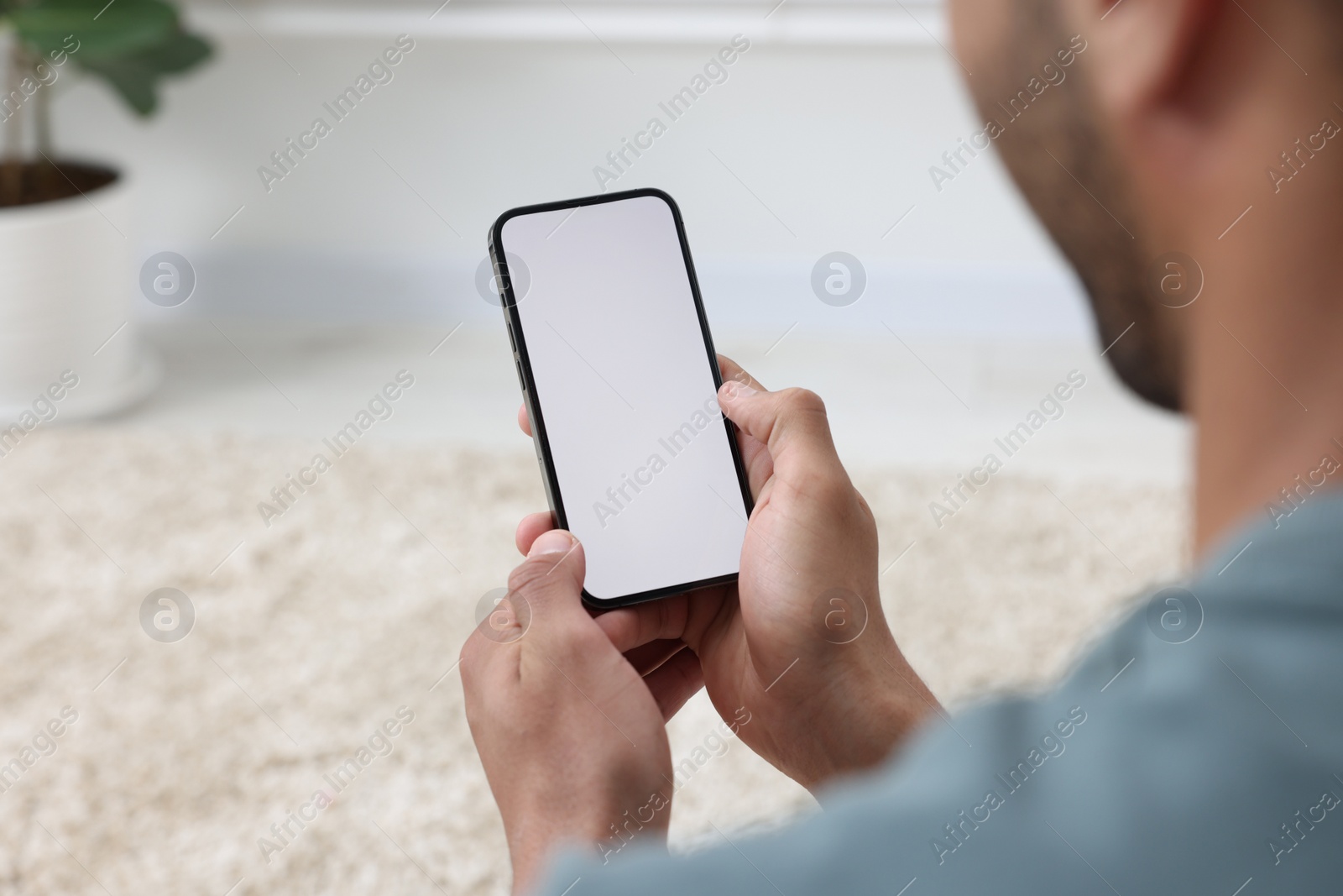 Photo of Man using modern mobile phone indoors, closeup