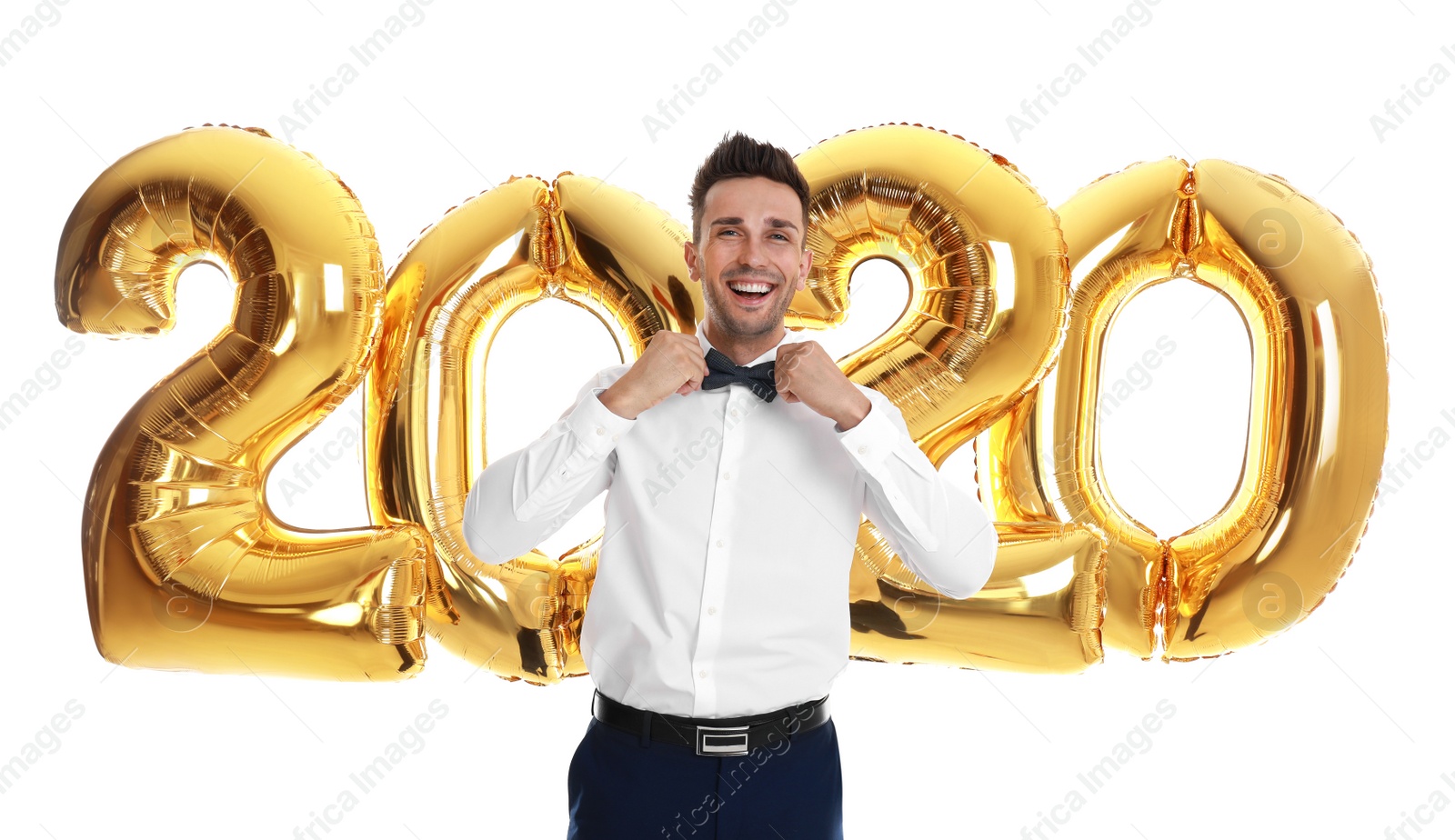 Photo of Happy young man near golden 2020 balloons on white background. New Year celebration