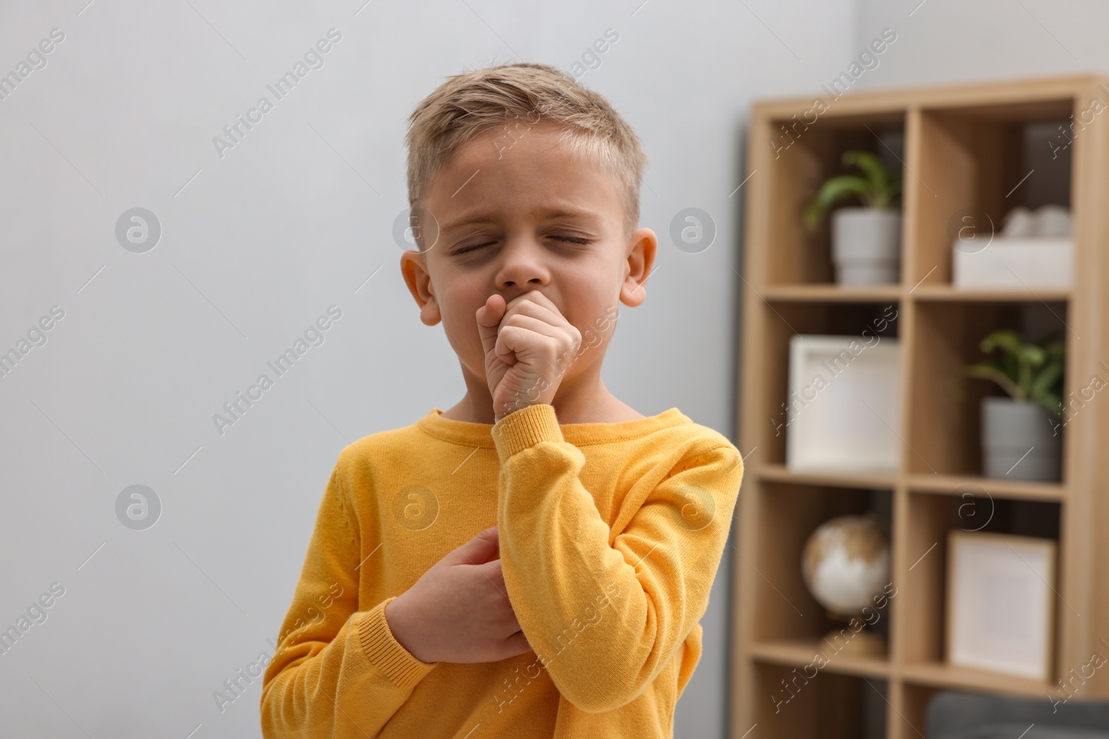 Photo of Sick boy coughing at home. Cold symptoms