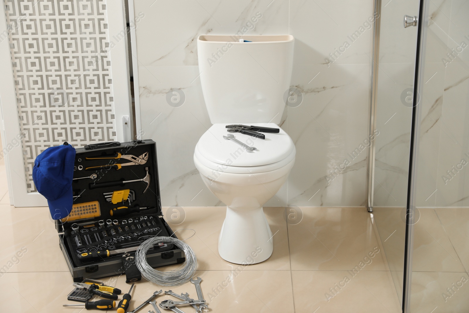 Photo of Plumber's tools near toilet bowl in bathroom