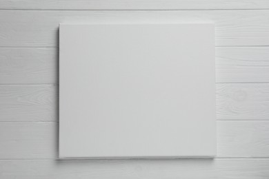 Photo of Blank canvas on white wooden background, space for text