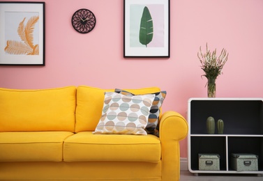 Photo of Modern living room interior with comfortable yellow sofa near color wall