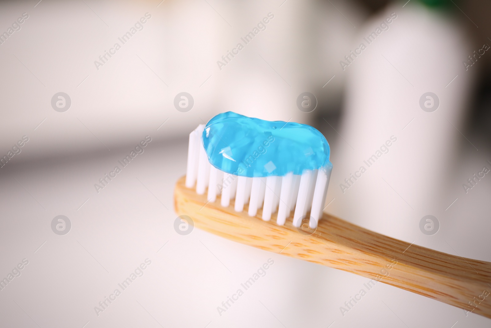 Photo of Toothbrush with paste on blurred background, closeup