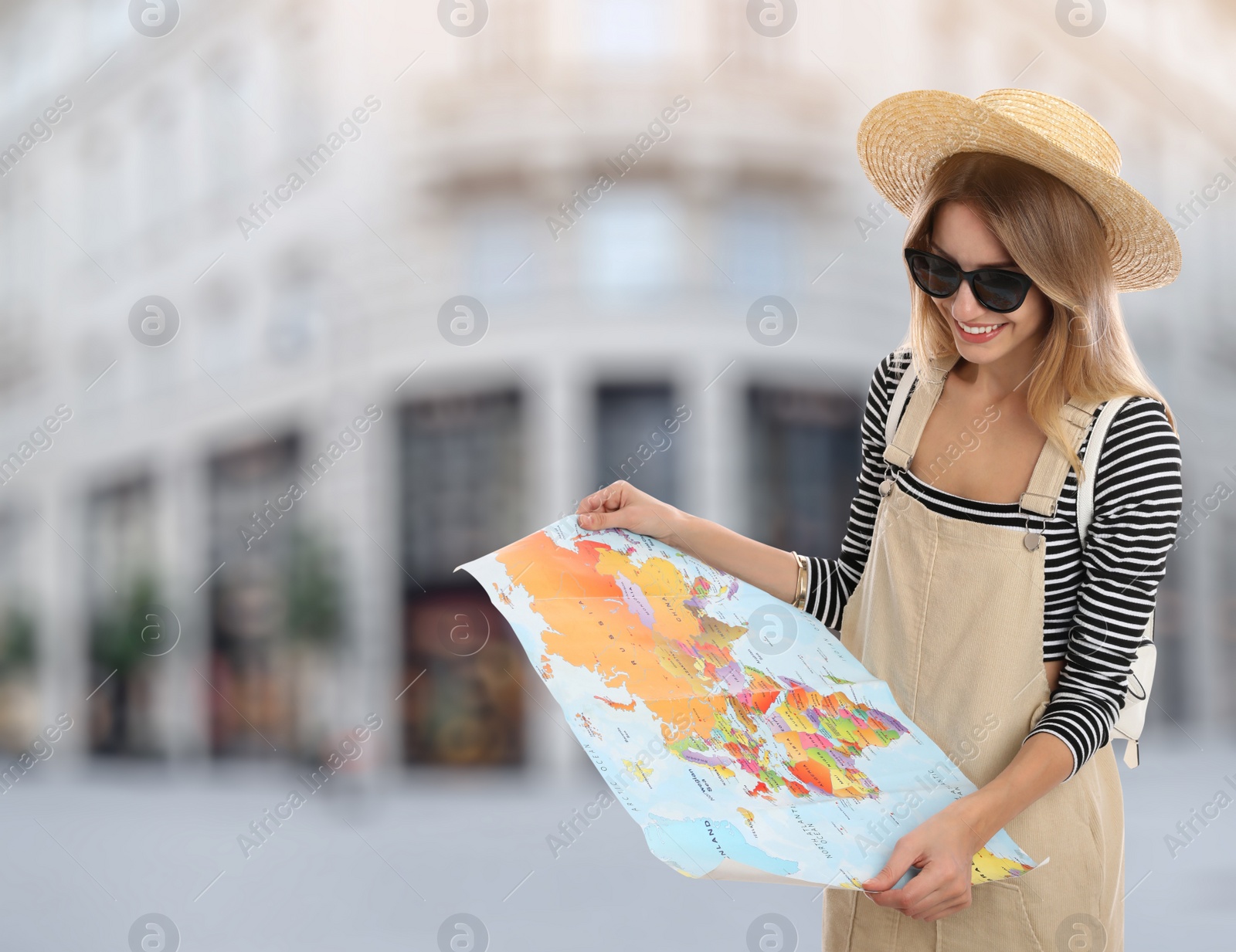Image of Happy traveler with map in foreign city. Summer vacation trip