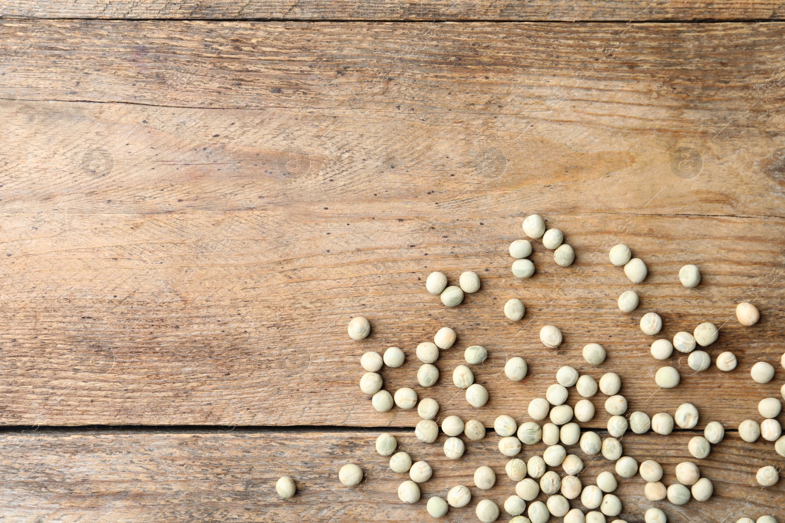 Photo of Raw dry peas and space for text on wooden background, flat lay. Vegetable seeds