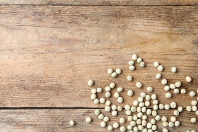 Photo of Raw dry peas and space for text on wooden background, flat lay. Vegetable seeds