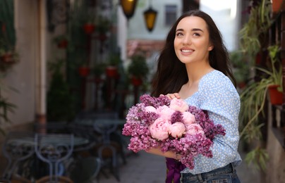 Photo of Beautiful woman with bouquet of spring flowers outdoors, space for text