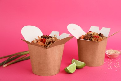 Photo of Boxes of wok noodles with seafood on pink background