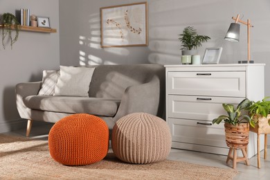 Stylish knitted poufs and sofa in living room. Home design