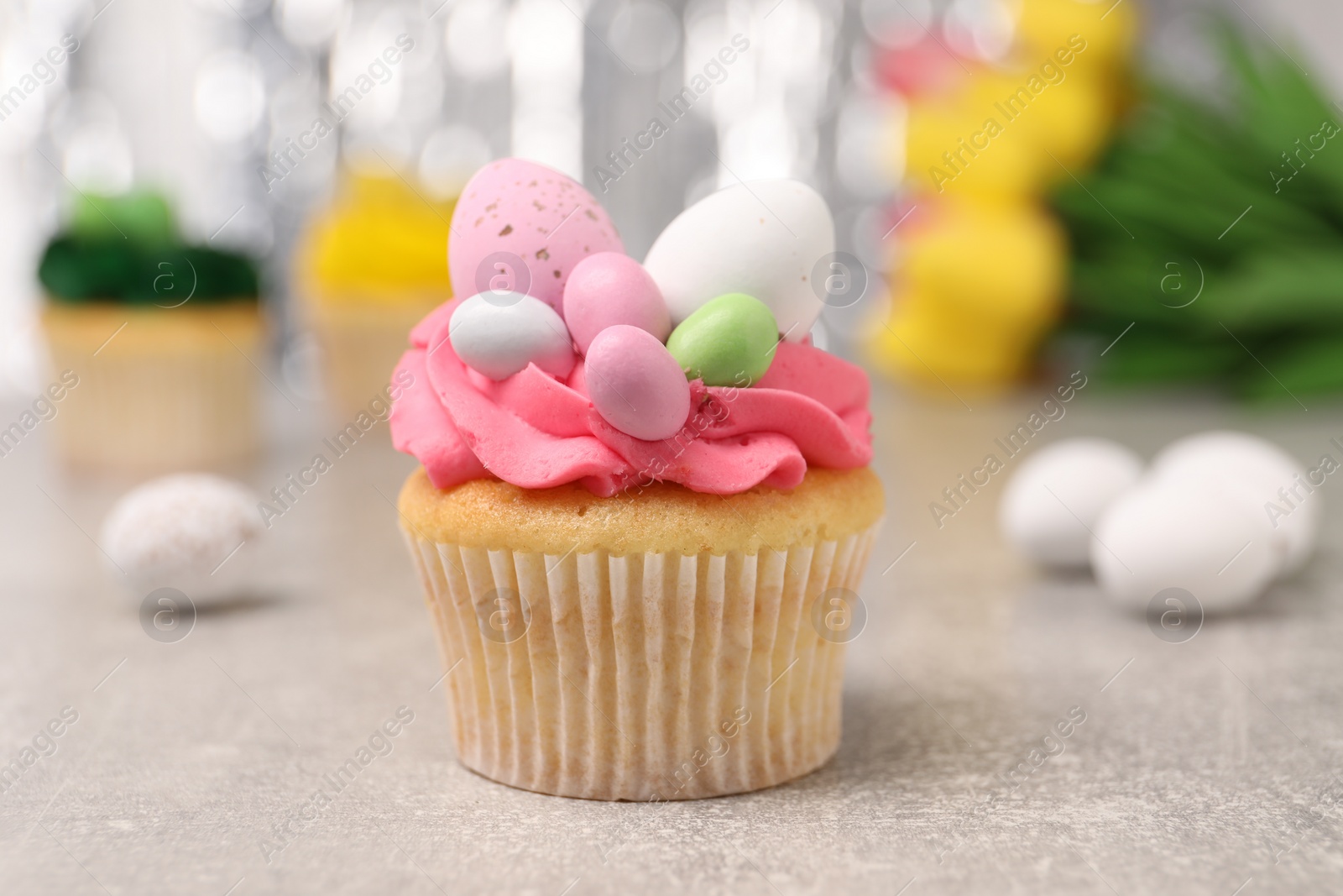 Photo of Tasty decorated Easter cupcake on grey table, closeup