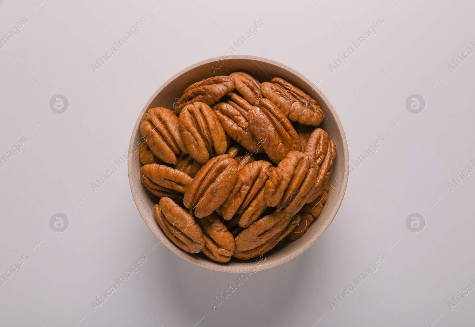 Photo of Tasty fresh ripe pecan nuts on white background, top view