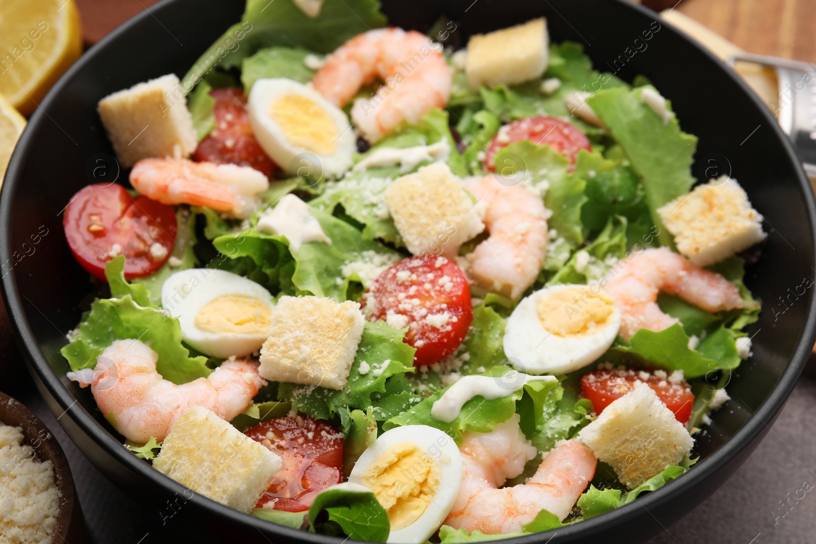 Photo of Delicious Caesar salad with shrimps on table, closeup