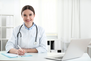 Photo of Portrait of young female doctor in white coat at workplace