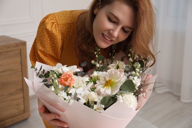 Beautiful woman with bouquet of flowers indoors