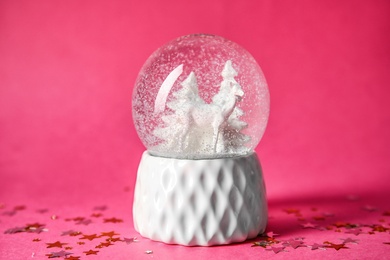 Photo of Snow globe with deer and trees on color background