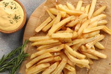 Delicious french fries served with sauce on grey table, flat lay