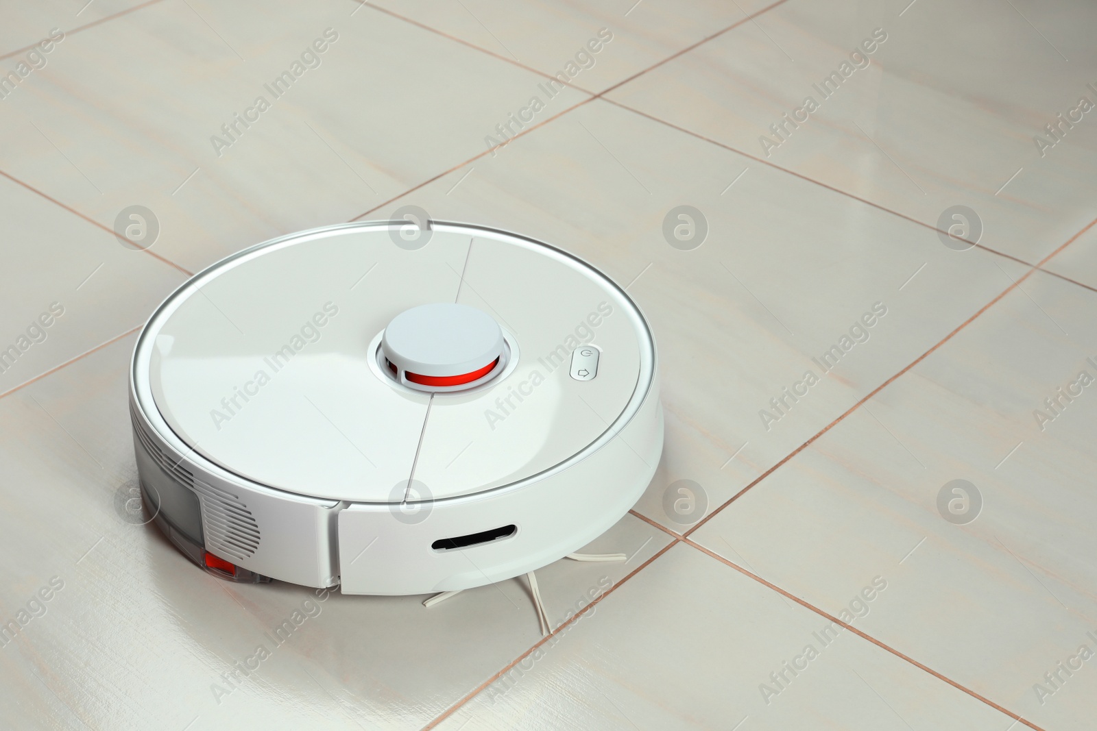 Photo of Robotic vacuum cleaner on white tiled floor, space for text