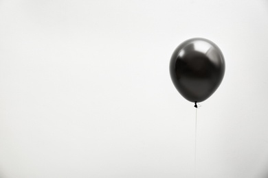 Photo of Black balloon on light background, space for text. Halloween party