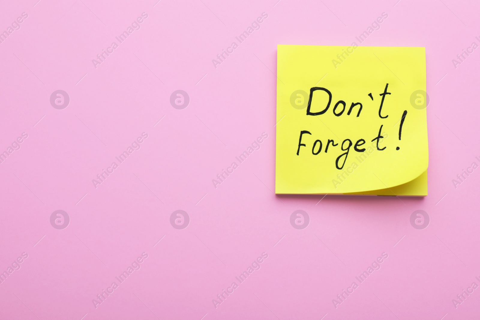 Photo of Paper note with phrase Don't Forget on pink background, top view. Space for text