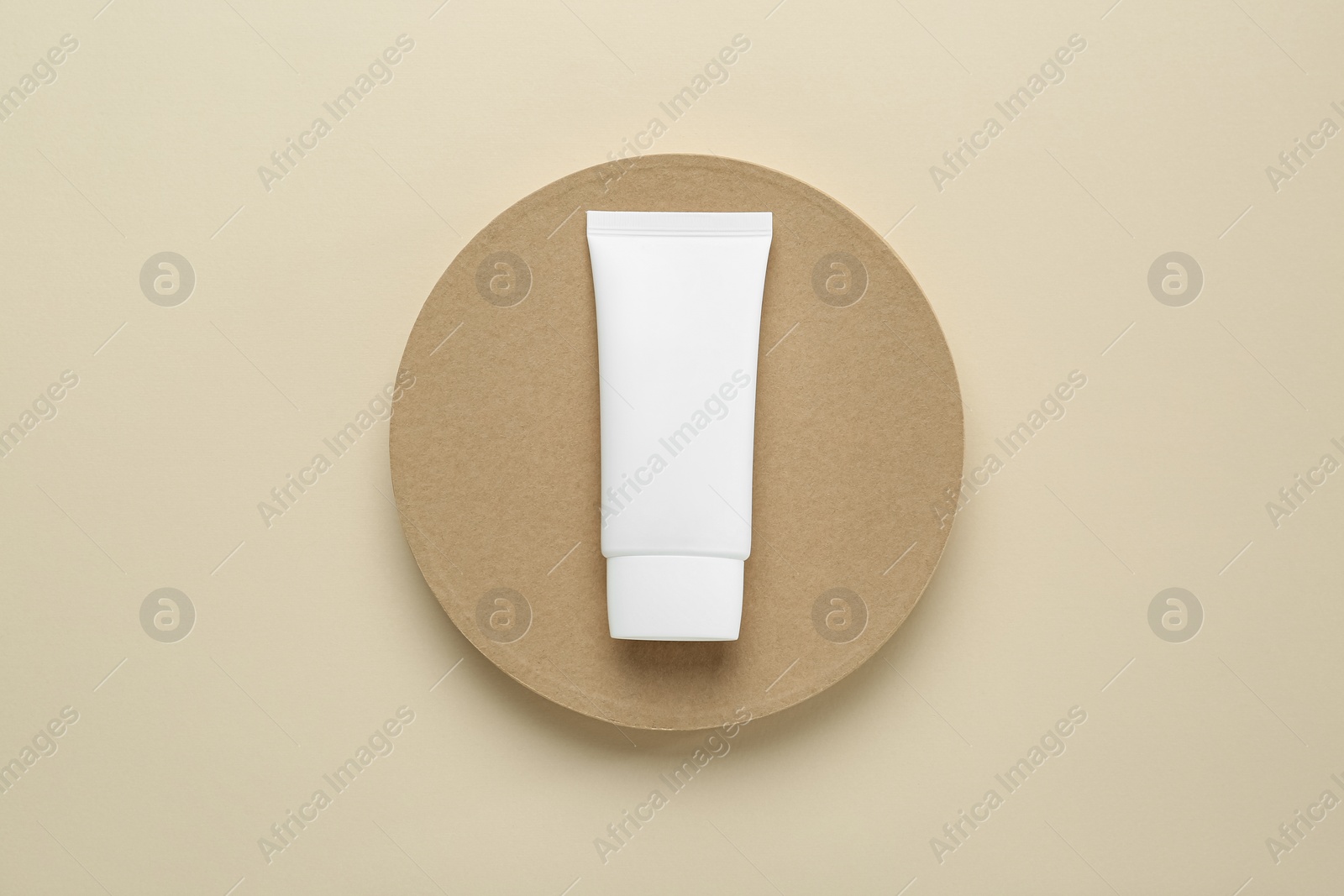 Photo of Tube of hand cream on beige background, top view