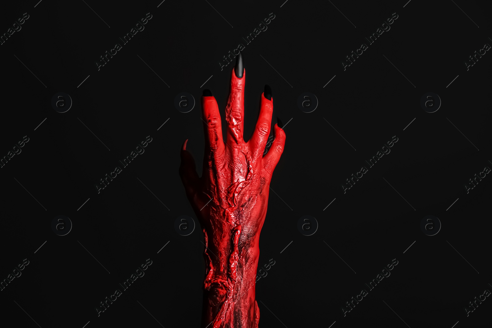 Photo of Scary monster on black background, closeup of hand. Halloween character