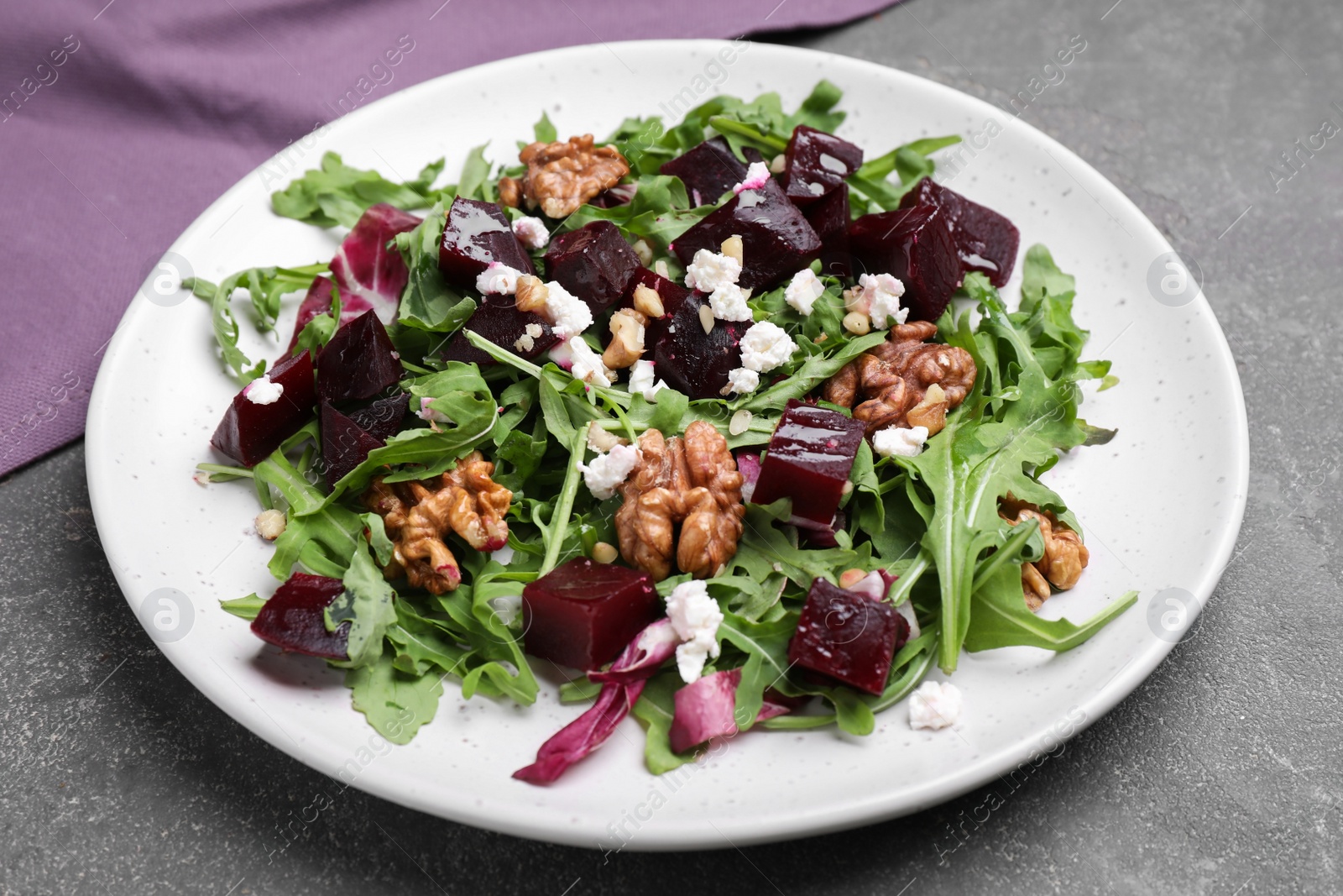 Photo of Delicious beet salad served on grey table, closeup